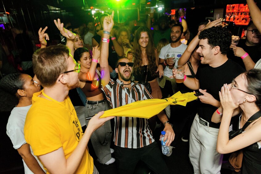 Una fiesta concurrida con gente bailando y sosteniendo bebidas. 3
