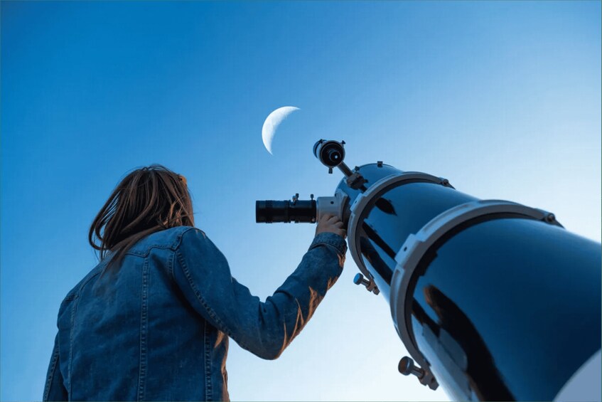 A person using a telescope to observe the moon. 2