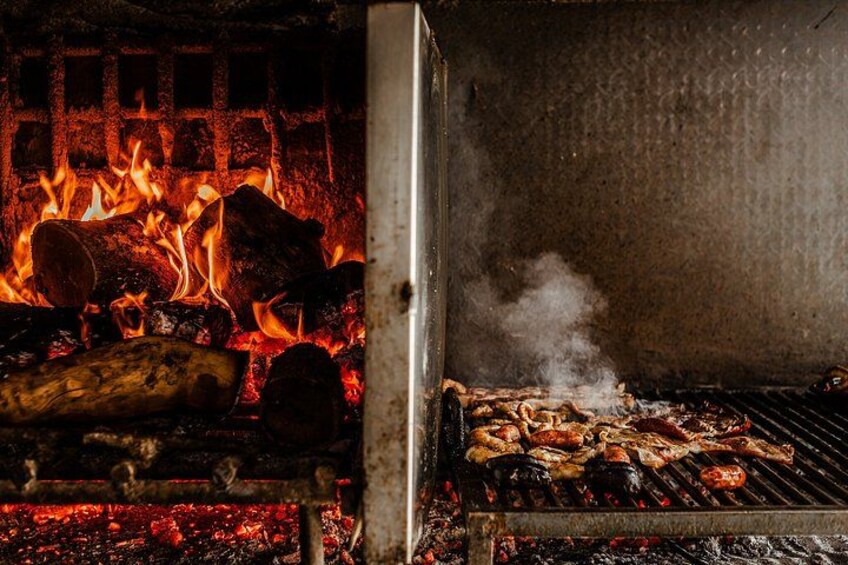 A grill with meat cooking over an open flame. 2