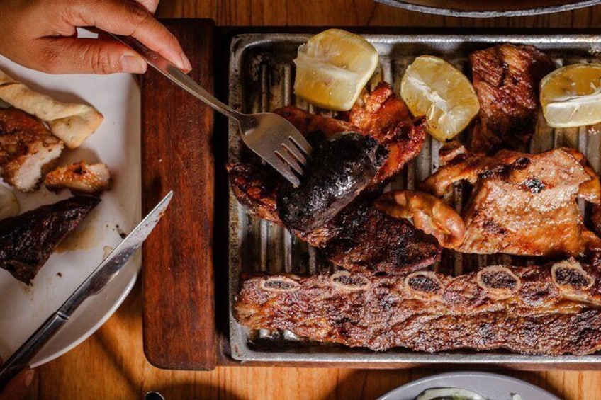 Un plat de grillades composé de différentes sortes de viande et de tranches de citron. 2