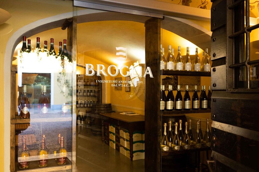 A wine shop interior with shelves of wine bottles and a glass display case. 4