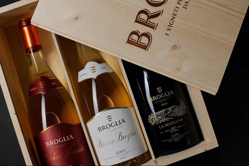 A wooden box containing three wine bottles with labels. 5
