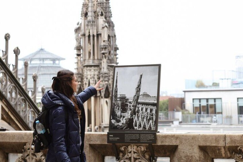 Eine Person zeigt auf ein historisches Gebäude mit aufwendiger Architektur. 2