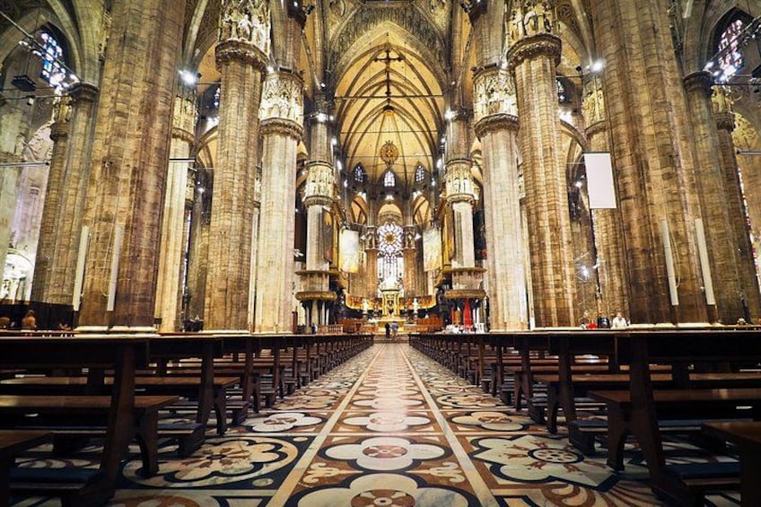 A cathedral interior with high vaulted ceilings, large stone columns, and a long central aisle. 2