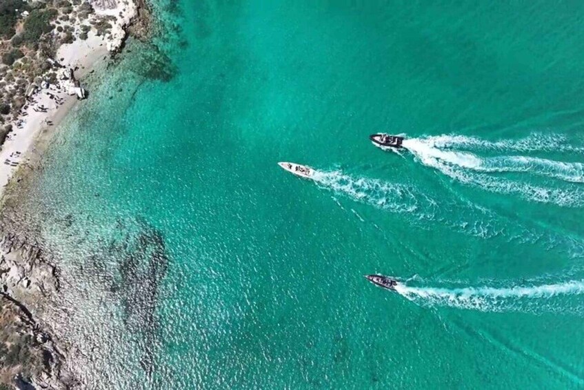 Two speedboats on turquoise waters with a beach on the left. 4