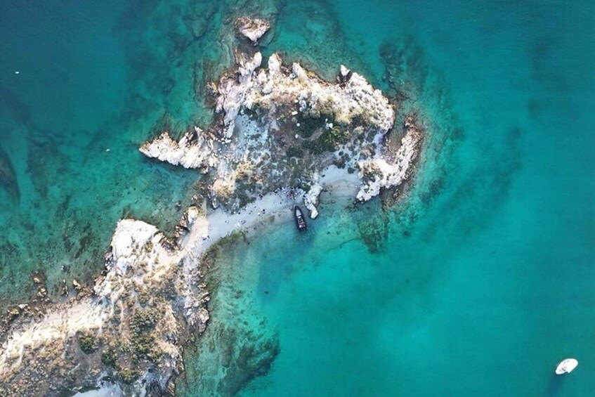 A rocky island surrounded by clear turquoise waters. 1