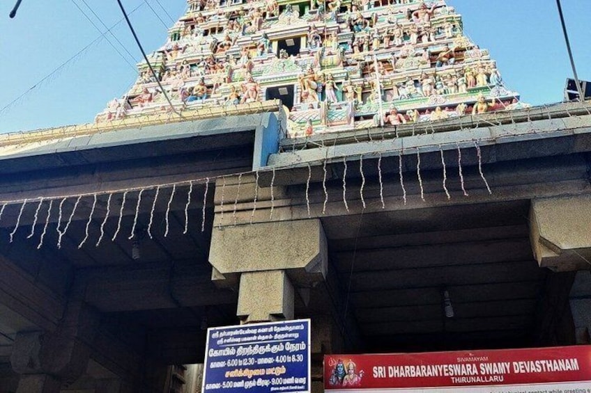 A temple with intricate carvings and a signboard. 3