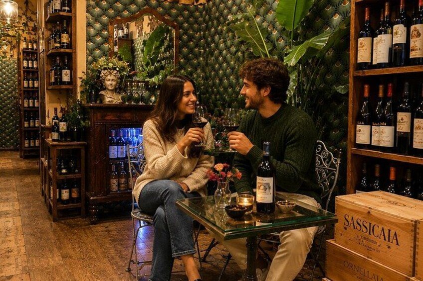 A cozy indoor setting with a wooden table, wine bottles, and a box labeled 'SASSICAIA.' 2