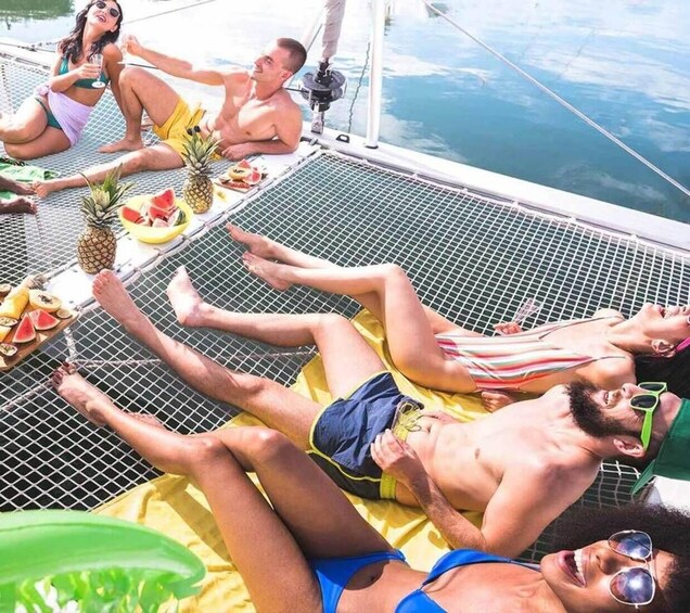 People relaxing on a boat deck with food and drinks. 1