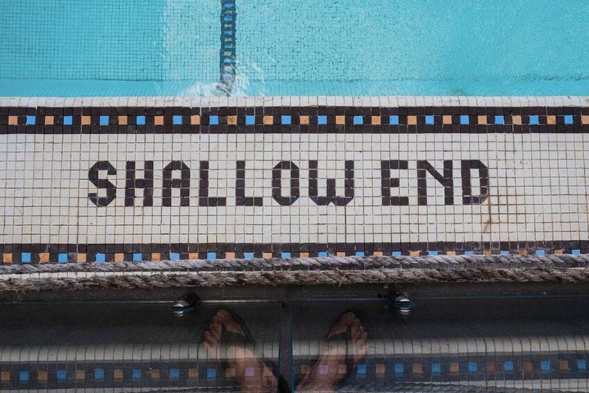 En pool med flisekant og et rebsikre, markeret 'SHALLOW END'. 2