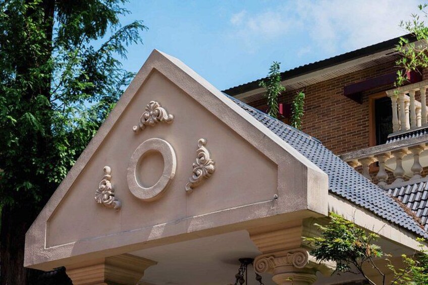 En bygning med en trekantet gavlvendt, et rundt vindue og dekorative detaljer. 5