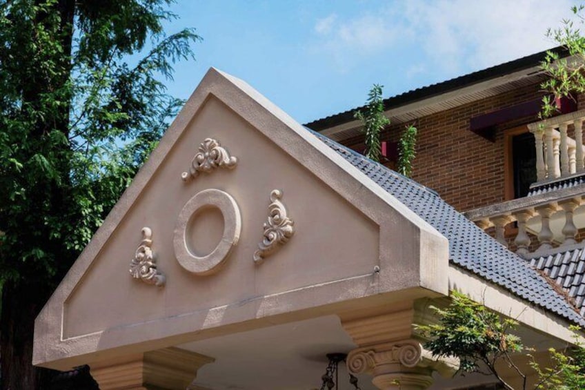 Un bâtiment doté d’un fronton triangulaire, d’une fenêtre circulaire et d’éléments décoratifs. 5