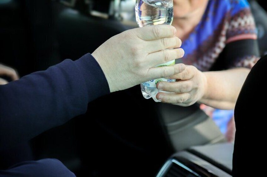 A person holding a bottle of water. 1