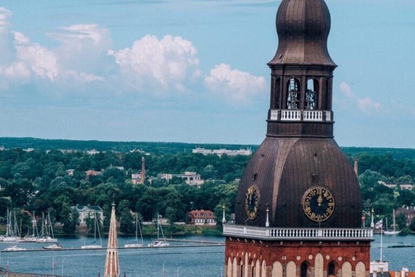 A clock tower with a dome and a spire in the background. 4