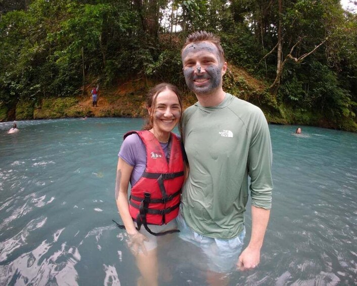 Two people in a natural water setting surrounded by dense greenery. 5