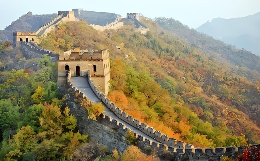 The Great Wall of China winding through a mountainous landscape with autumn foliage. 4