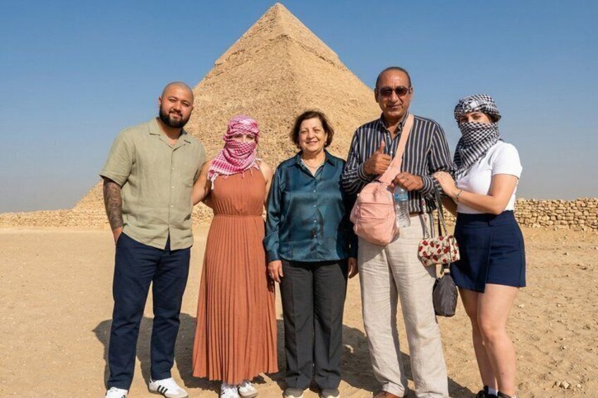 A group of people standing in front of a pyramid. 5