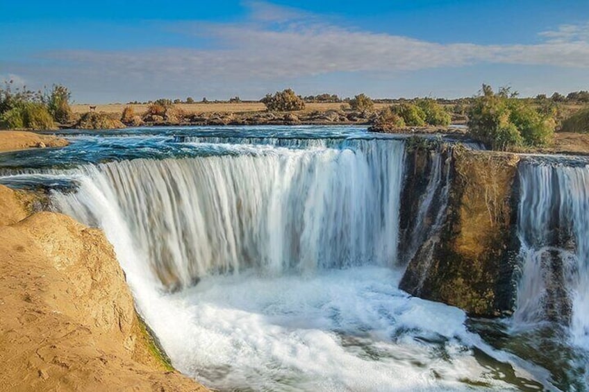 A waterfall cascading over a rocky cliff into a river. 1