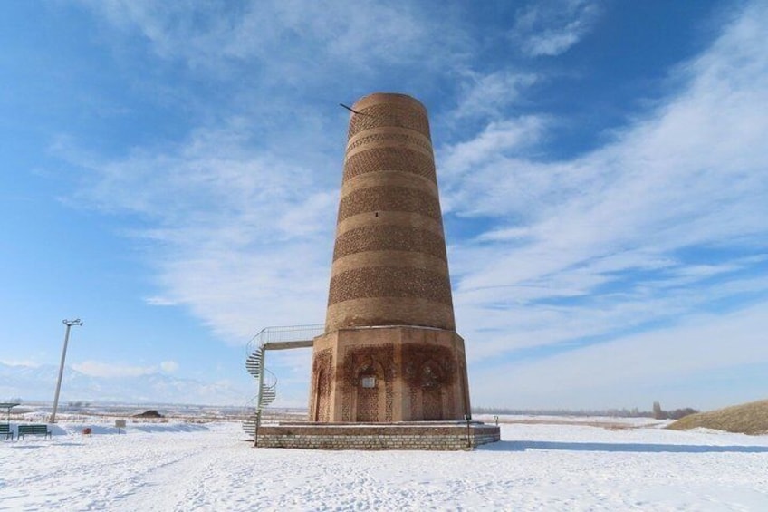 A tall, cylindrical structure with a spiral staircase, set against a snowy landscape with a clear sky. 5