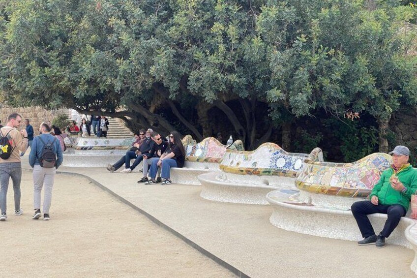 A park with colorful benches and people walking. 3