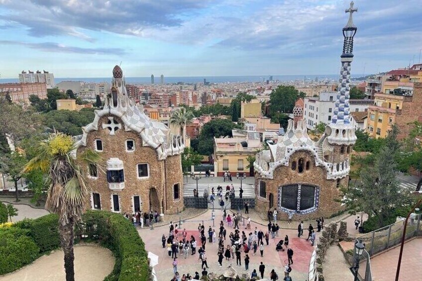 A large, ornate building with a tower, surrounded by a plaza with people. 1