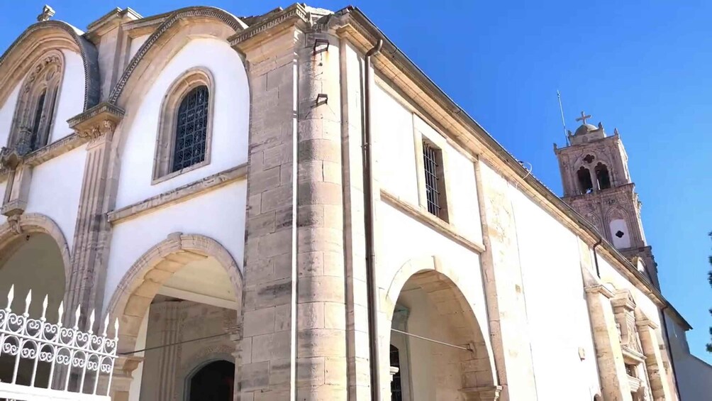 A historic building with arched doorways and a bell tower. 3