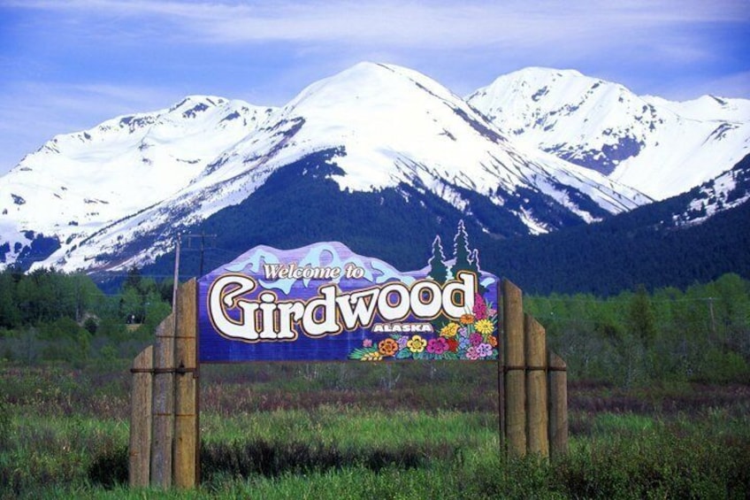 Un panneau accueillant les visiteurs à Girdwood, en Alaska, avec des montagnes enneigées en arrière-plan. 3