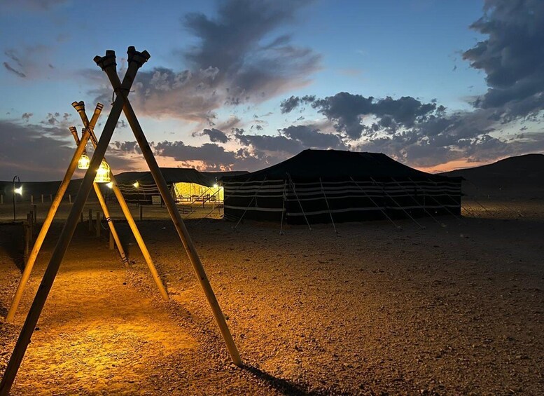 A traditional yurt with a wooden frame and a thatched roof, set against a twilight sky. 4