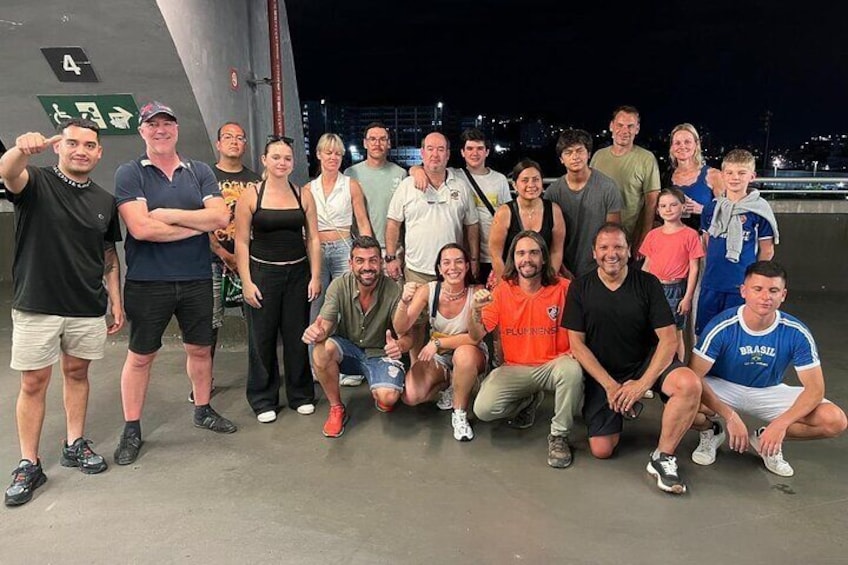Un grupo de personas posando para una foto en una azotea, con un horizonte urbano de fondo. 4