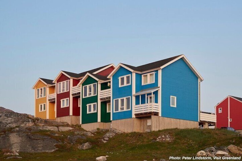 A row of colorful houses with a rocky landscape in the foreground. 2