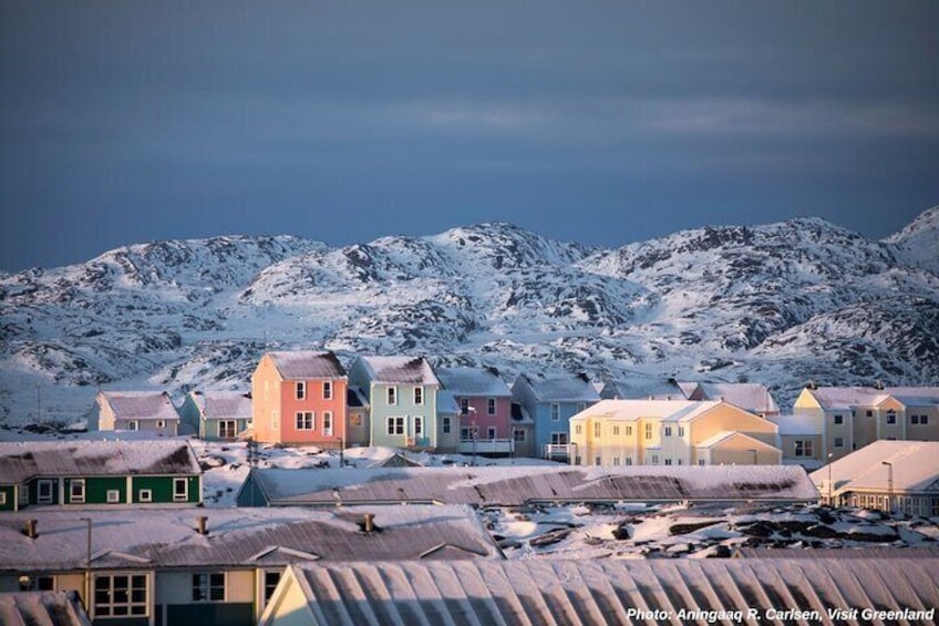 A snow-covered town with colorful houses and mountains in the background. 3