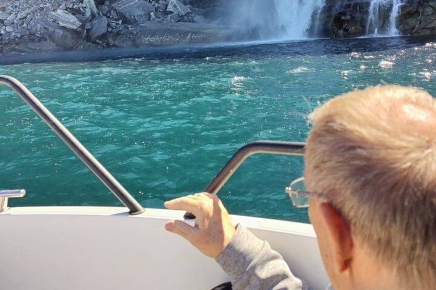 A person on a boat looking at a waterfall. 3