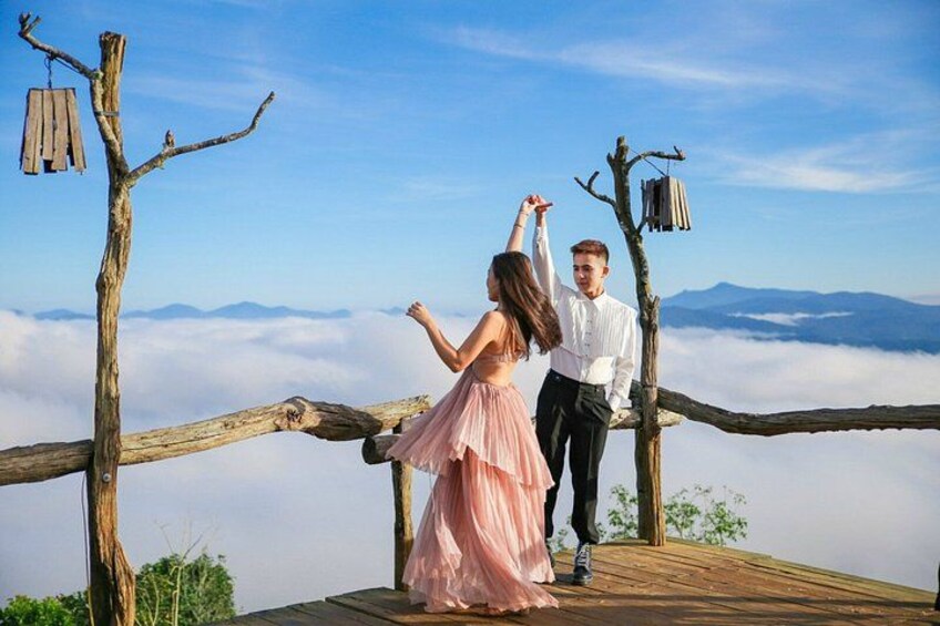 A couple dancing on a wooden platform with a mountainous backdrop. 5