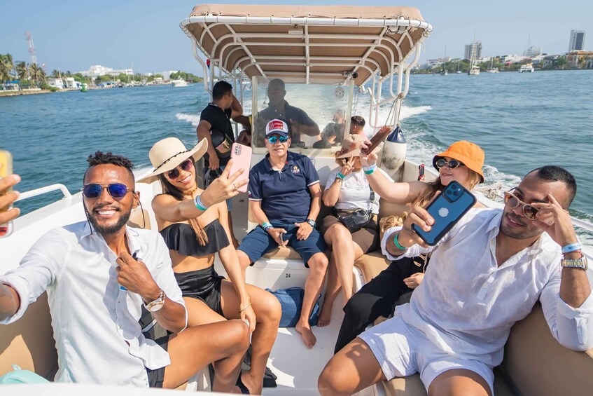 A group of people on a boat, some holding smartphones, with a cityscape in the background. 4
