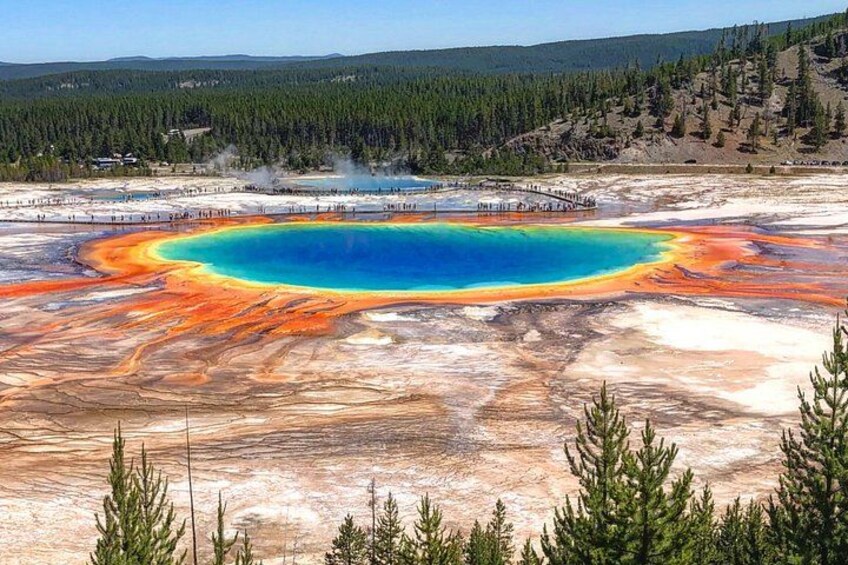 Una sorgente termale geotermica con un nucleo blu intenso circondata da depositi minerali arancioni e rossi. 3