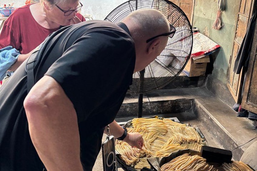 Una persona sta preparando del cibo, con una ventola e una scatola di ingredienti in vista. 2