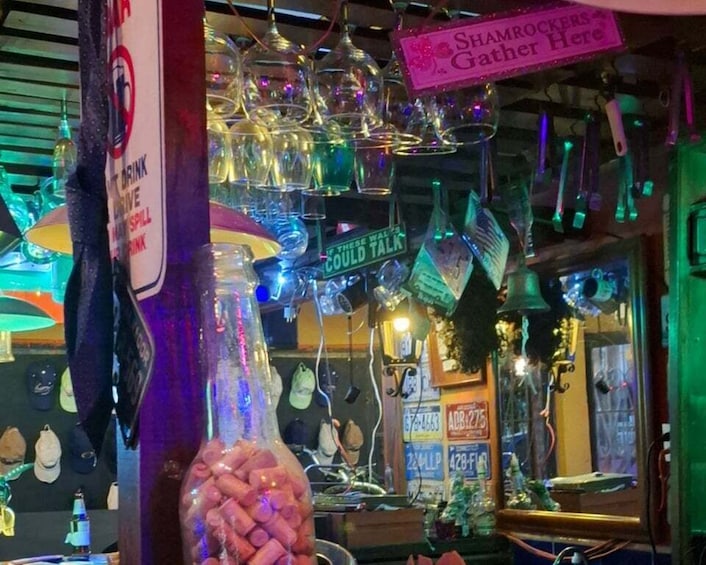 A bar with hanging glasses and a sign that says 'Shamrockers Gather Here.' 2
