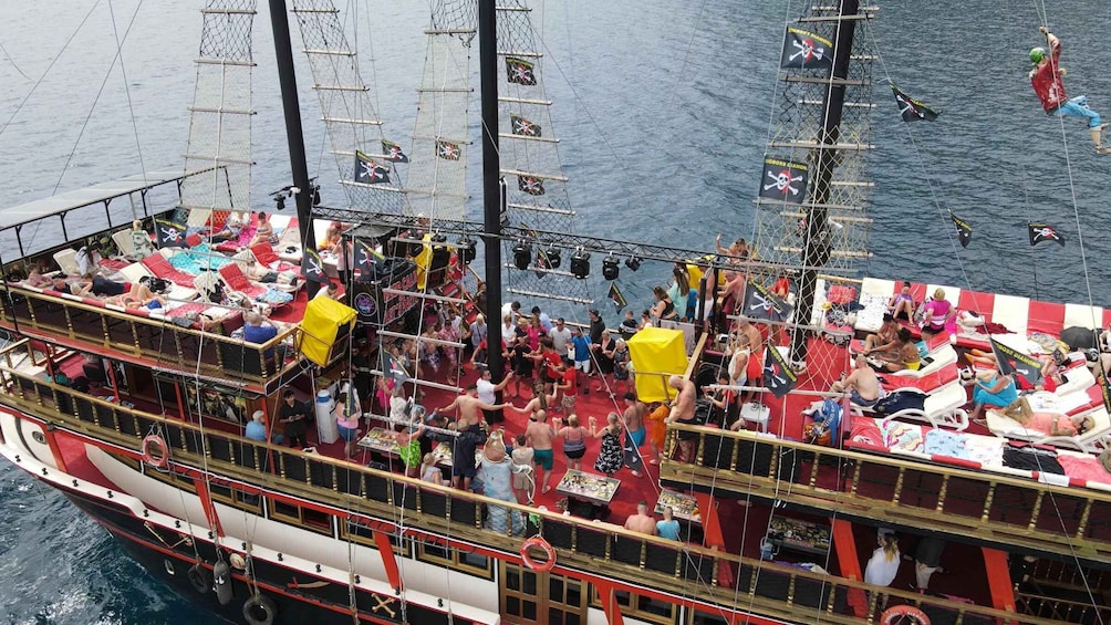 A crowded, multi-deck ship with people lounging and socializing. 4