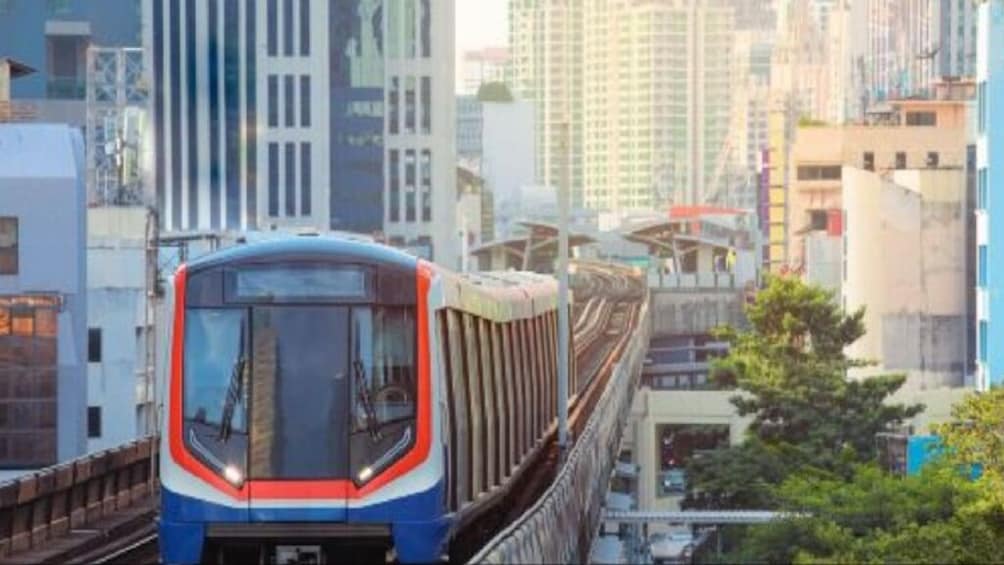 A train on elevated tracks in an urban setting with modern buildings. 5