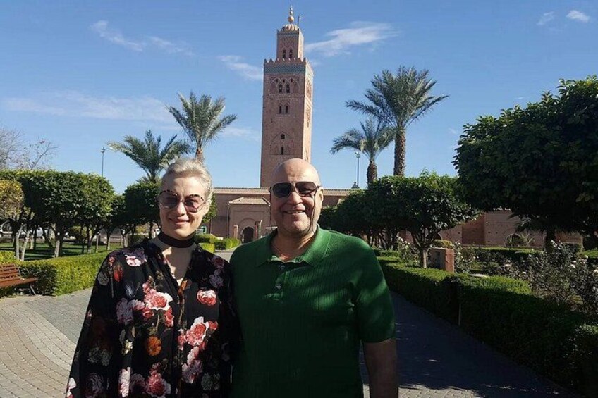 Two people standing in a landscaped area with a tall tower in the background. 4