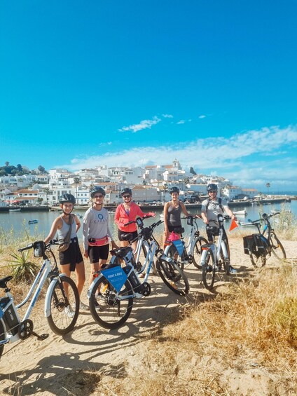A group of people with bicycles by a waterfront. 1