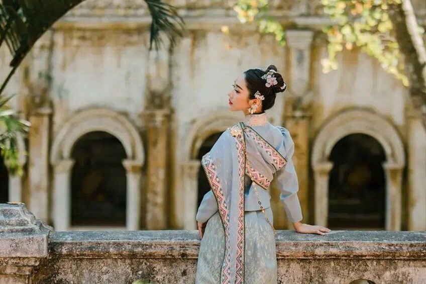 A person standing in front of an ornate building with arches. 1