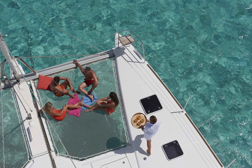 A group of people relaxing on a boat with a clear view of the turquoise sea. 4