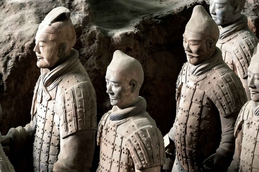 Terracotta soldiers in formation, wearing detailed armor, set in a rocky terrain. 5