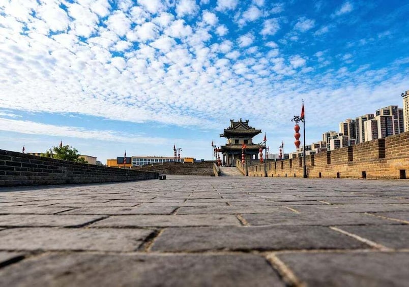 A traditional Chinese gate with a clear sky and distant buildings. 3
