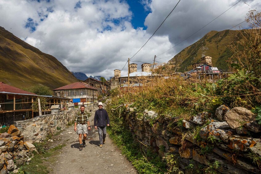 A mountainous village with stone walls, traditional houses, and a clear sky. 4