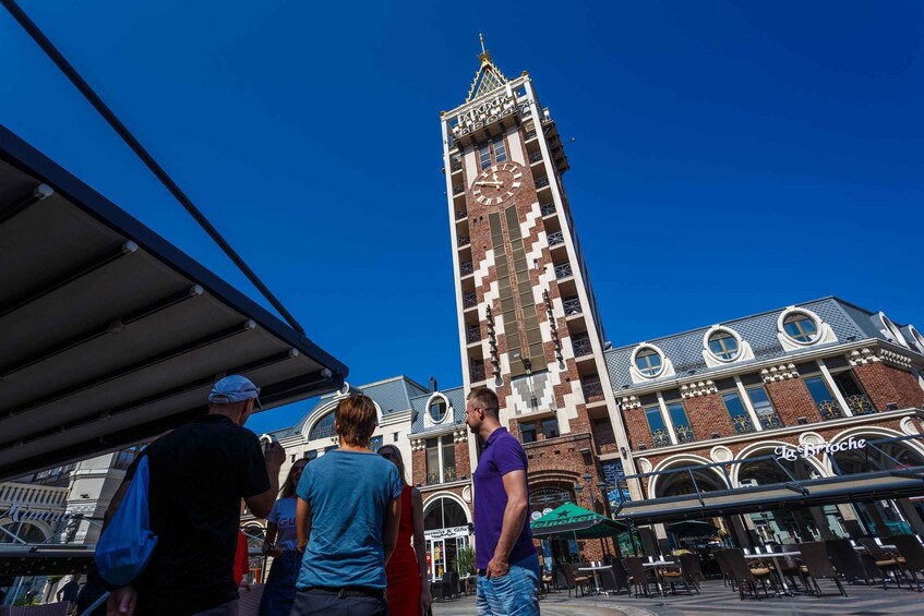A clock tower, outdoor seating, and a building with a distinctive facade. 2