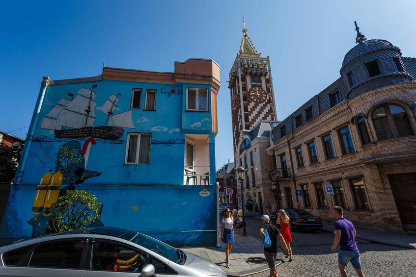 A blue building with a ship mural, a clock tower, and a dome. 4