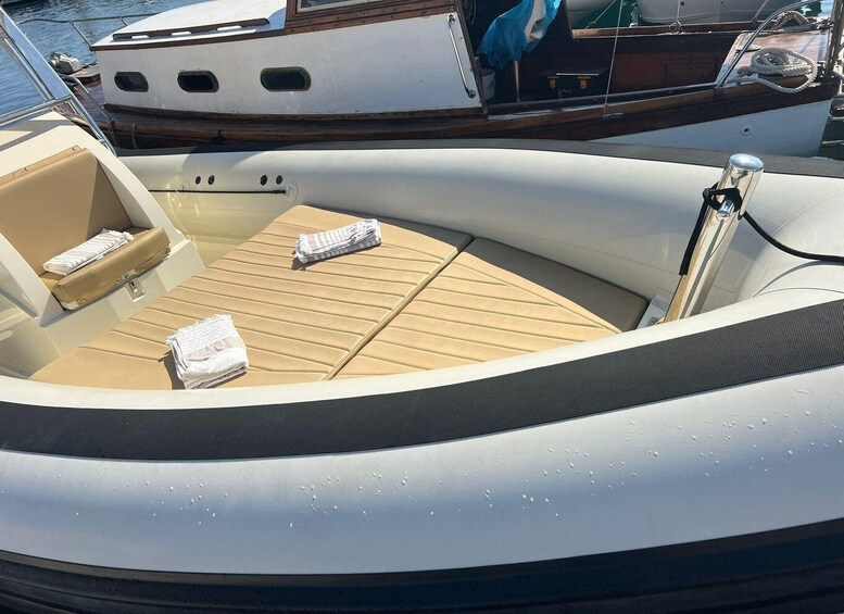 A boat's interior with cushioned seating and a wooden deck. 3