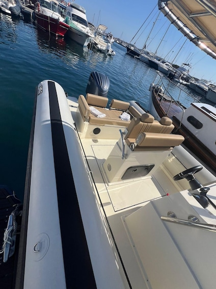 A boat docked at a marina with other boats, a clear sky, and a calm water surface. 5